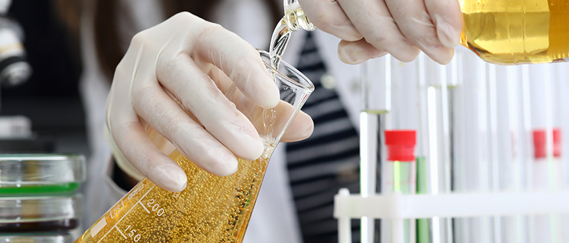 Beer being poured into measuring flask in laboratory