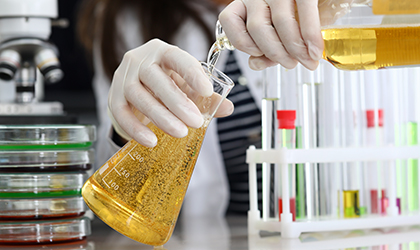 Beer being poured into measuring flask in laboratory