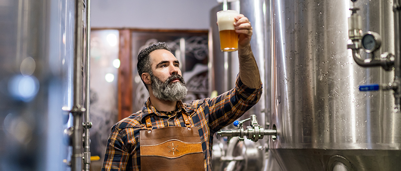 Brewer sampling beer in brewery