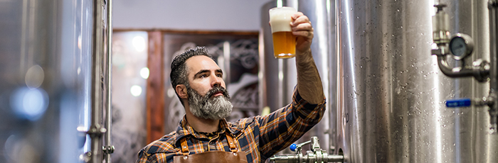 Brewer sampling beer in brewery