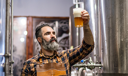 Brewer sampling beer in brewery