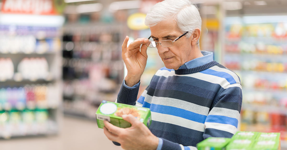 Male food shopper reading food product label