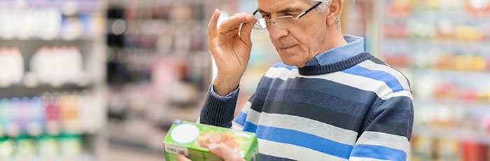 Male food shopper reading food product label