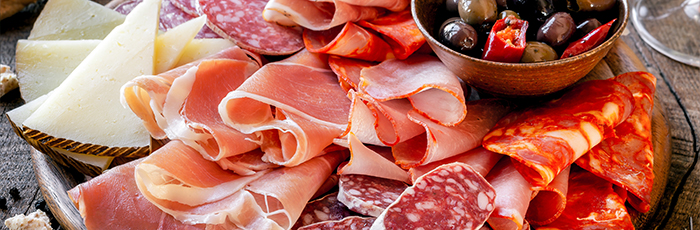 Cured meat selection on board with olives and cheese