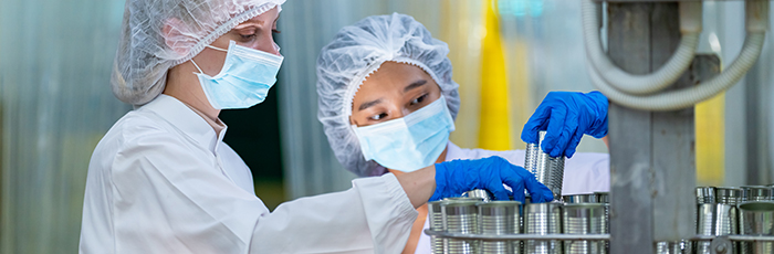 Factory workers checking food cans during audit