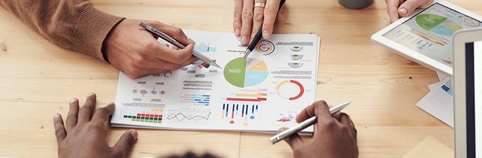 Business meeting with people discussing tactics and strategies with charts on paper