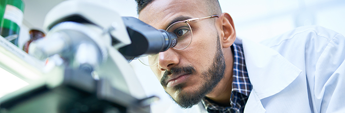 Scientist looking into microscope