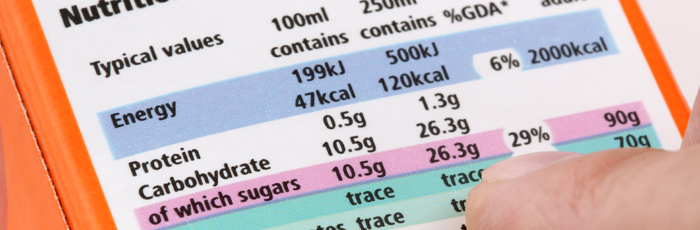 Finger pointing at nutritional values label on food packaging