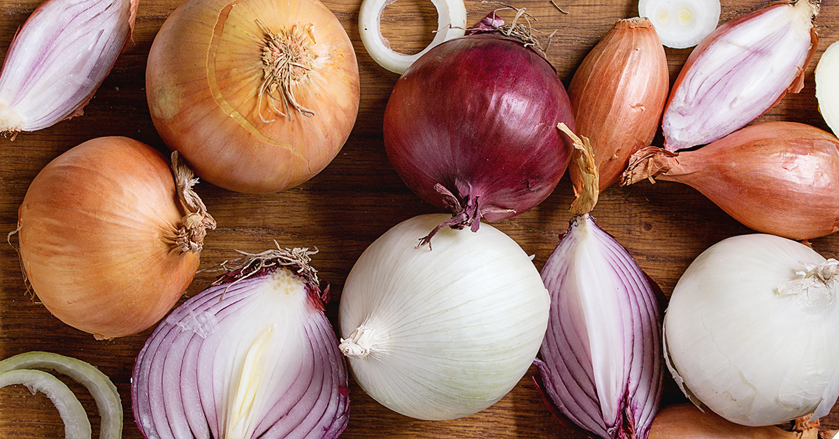 Selection of onions on chopping board