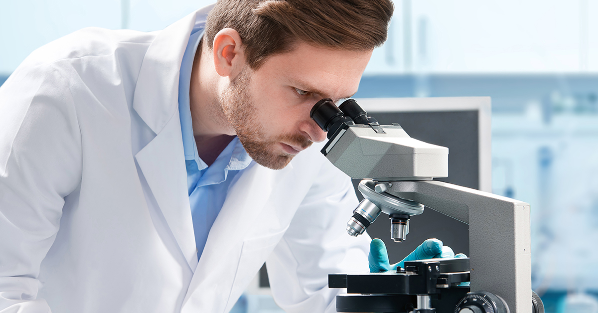 Scientist looking down a microscope