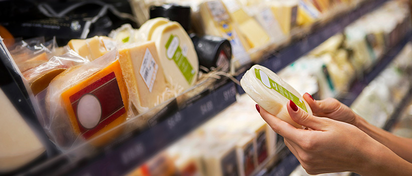 woman holding cheese in shop