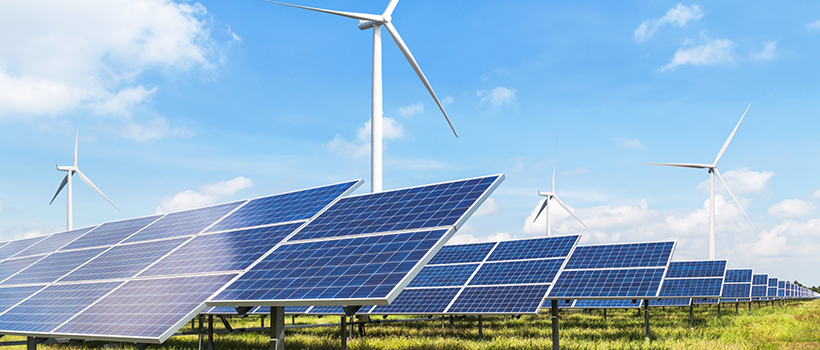 Solar panels and wind turbines in field