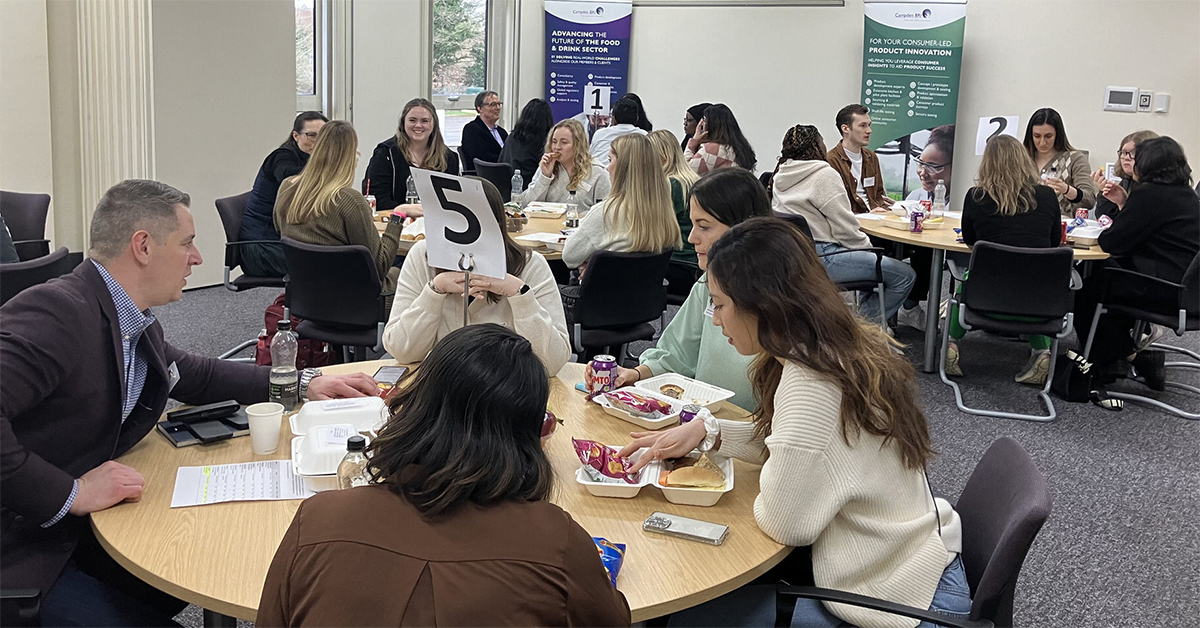 Students networking around tables in seminar room