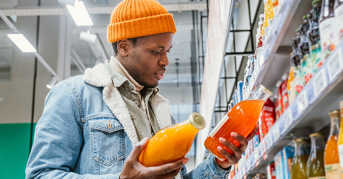 Shopper comparing fruit juices in supermarket