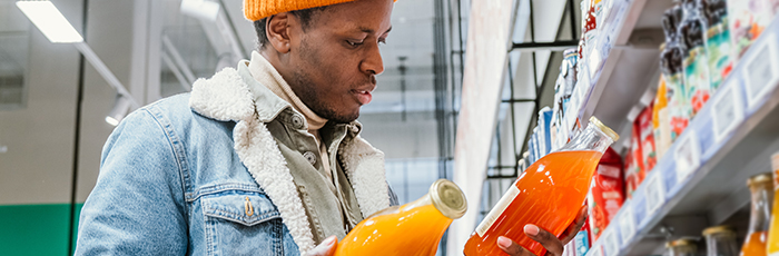 Shopper comparing fruit juices in supermarket