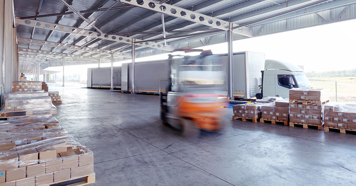 Supply truck being unloaded by forklift in a factory