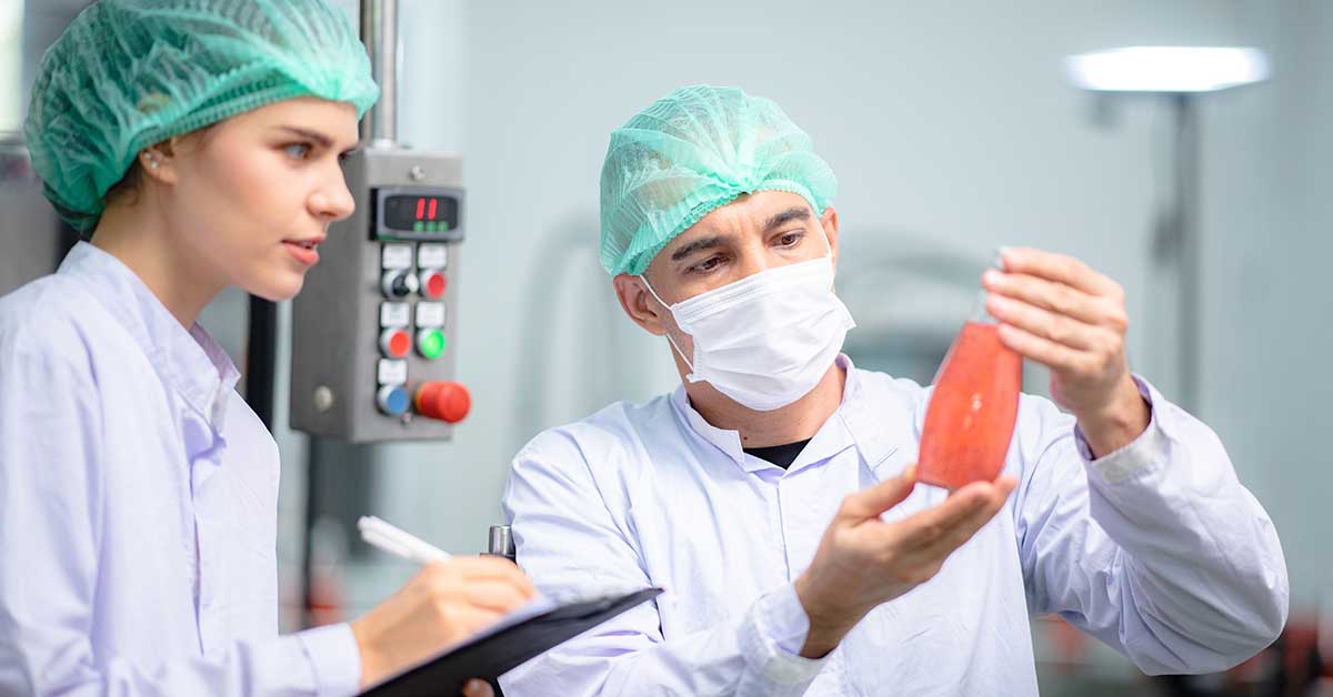Technicians inspecting drink product in factory