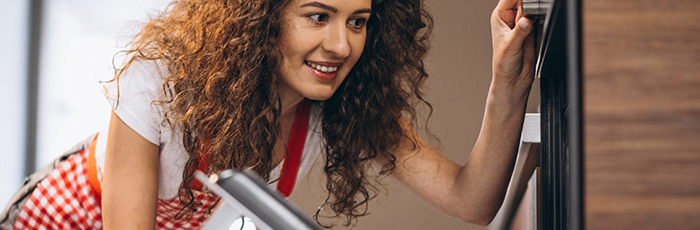 Woman opening oven door